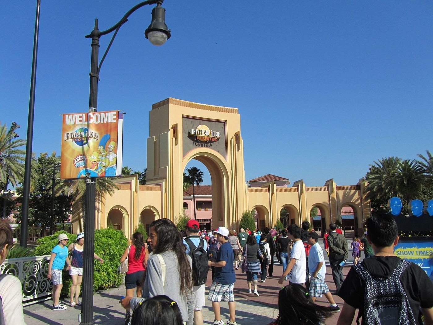 Arco de entrada do Universal Orlando Resort com visitantes chegando ao parque